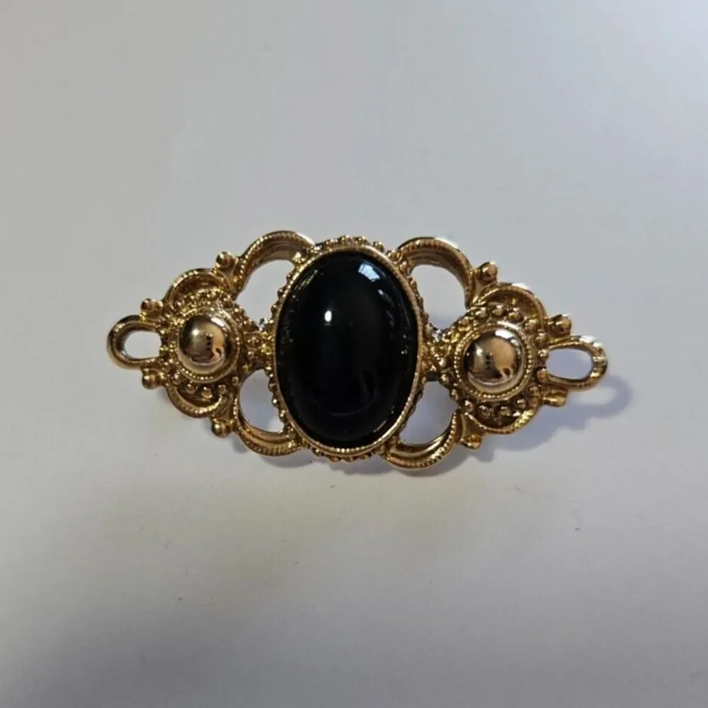 1928 brand gold tone with black brooch